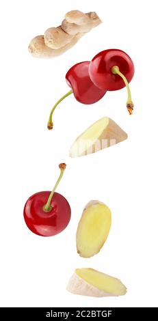 Isolated flying fruit. Falling cherry fruits and ginger roots isolated on white background with clipping path as package design element and advertisin Stock Photo