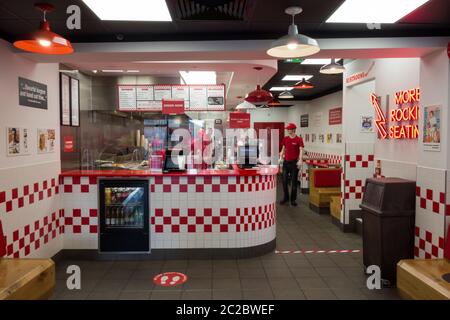 Social distancing signs and staff behind the counter at a 5 Guys fast-food restaurant in London, England, UK Stock Photo
