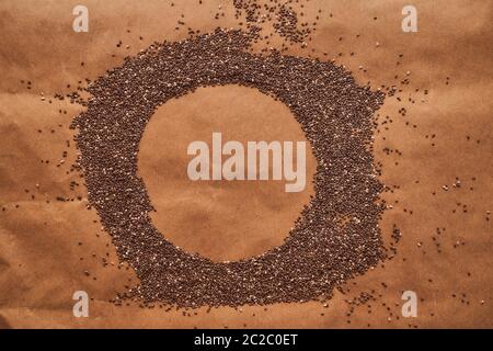 Circle-shaped chia seeds lie on a brown background Stock Photo