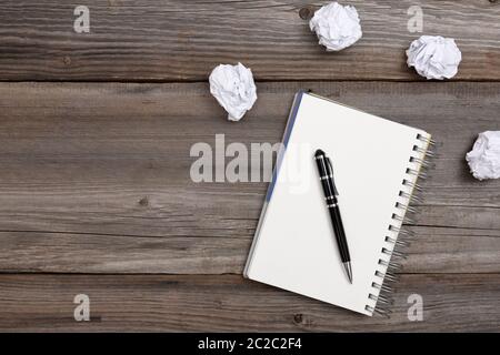 Notepad and pen with crumpled paper on wooden background. No ideas concept Stock Photo
