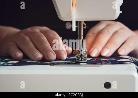 Woman hands using the sewing machine at home during quarantine Stock Photo