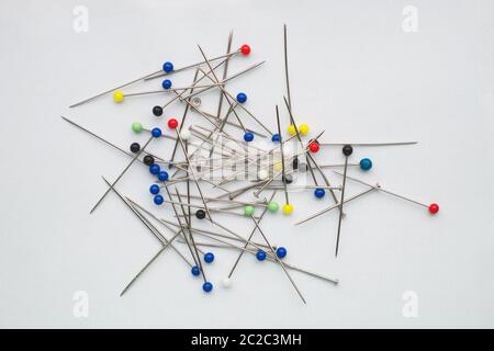 Many multi-colored sewing pins on a white background Stock Photo