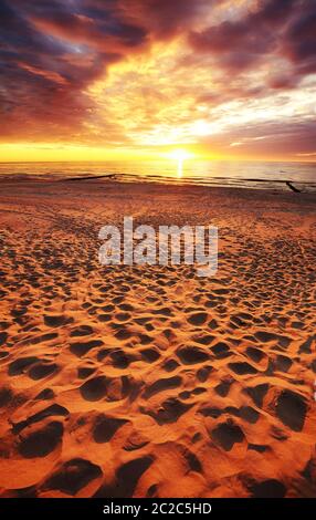 Sandy beach at beautiful sunset with dramatic sky. Stock Photo
