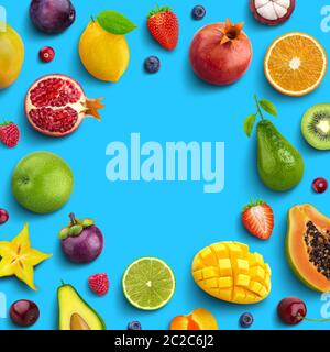 Various fruits and berries isolated on blue background, top view, creative flat layout, round frame of fruits with empty space f Stock Photo