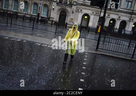 A person walks through heavy rain in London as violent thunderstorms swept across the north of England and Scotland, causing flash flooding in places. Stock Photo