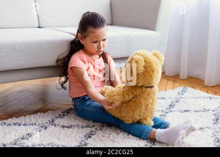 Asian Girl Sitting With Teddy Bear Suffering From Loneliness Indoors Stock Photo