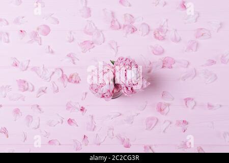 Feminine flat lay composition bouquet of fresh peony flowers on pink background with pattern of petals. Stock Photo