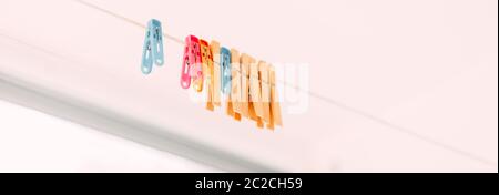Colored clothespins on a rope on a blurred background Stock Photo