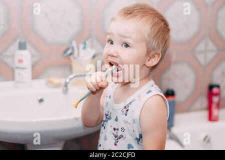 Little child toddler boy brushing his teeth in bathroom Stock Photo