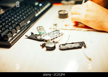 Image of engineer with soldering iron repairing mechanism Stock Photo