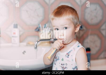 Little child toddler boy brushing his teeth in bathroom Stock Photo