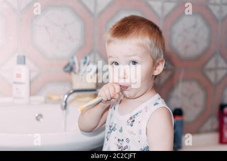 Little child toddler boy brushing his teeth in bathroom Stock Photo