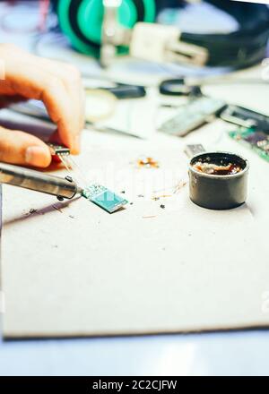 Image of engineer with soldering iron repairing mechanism Stock Photo