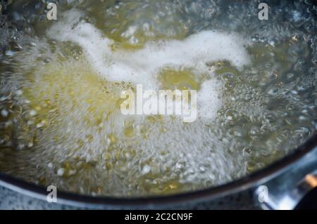 Italian pasta cooking in boiling salted water. Cooking pasta at home, close up. Stock Photo