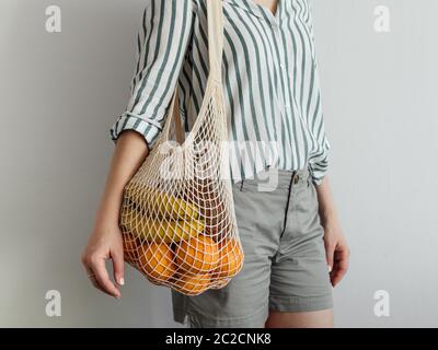 woman standing with mesh bag on shoulder Stock Photo
