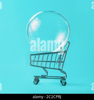 Shopping cart with soap bubble on blue background Stock Photo