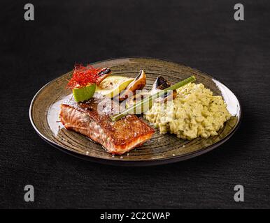 Grilled salmon served with grilled zucchini, champignon and basil risotto Stock Photo
