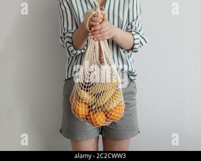 woman standing with mesh bag in hands Stock Photo