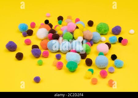 some felt balls  of various colors on a colored surface Stock Photo
