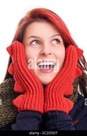 Close up shot of a beautiful surprised young woman with red mittens looking upwards, isolated on white background. Surprised young girl in winter clot Stock Photo