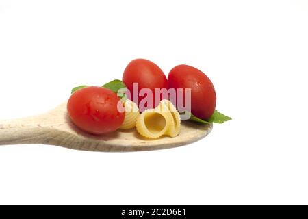 wooden spoon with pasta topped with cherry tomatoes Stock Photo
