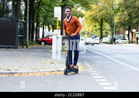 Young African Man Riding An Electric Scooter Stock Photo