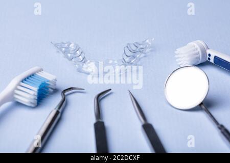 Dental Instruments And Clear Aligner On Color Background Stock Photo