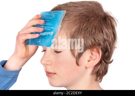 Child cools the forehead with a cold pack Stock Photo