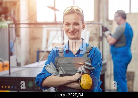 Workers in a metal workshop, man and woman Stock Photo