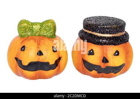 Halloween pumpkin isolated. Close-up of two decorations Halloween pumpkins one with black hat and other with a green hair bow made of ceramics isolate Stock Photo