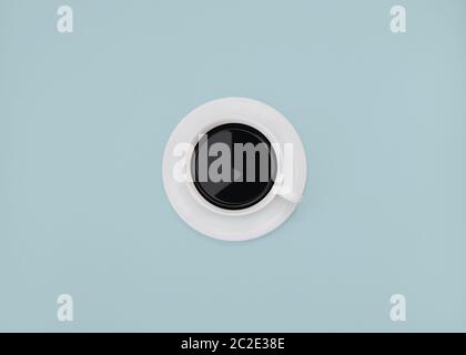 Black coffee Minimal style Cup of black coffee is standing on a blue background Stock Photo