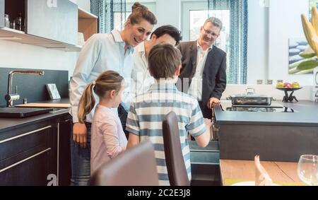 Kitchen sales with a family, kids, and a service expert in a modern showroom Stock Photo