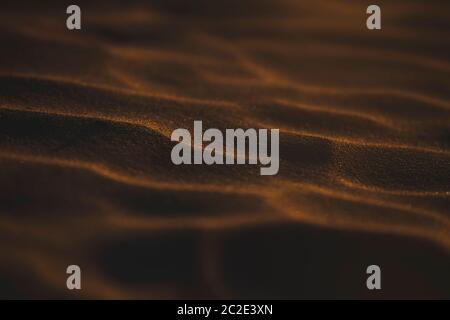 Patterns in sand on a beach with moody light at sunset. Stock Photo