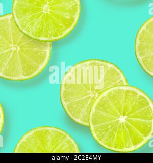 A seamless pattern of lime slices on a vibrant teal blue background, a fruity citrus repeat print Stock Photo