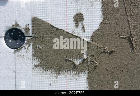 Insulation from expanded polystyrene, plaster, mesh and plastic dowel Stock Photo