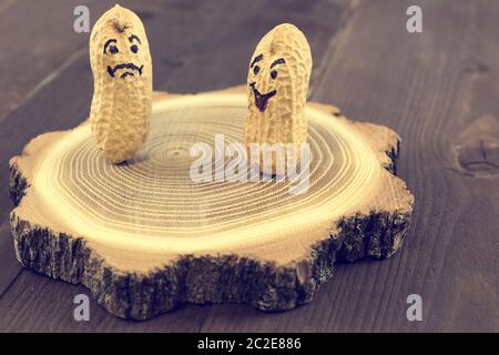 Happy and sad face drawn on dried peanuts. Concept for good mood or bad mood Stock Photo