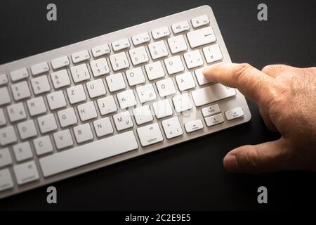typical computer keyboard with finger on enter Stock Photo