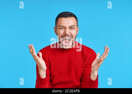 Screaming angry man on blue background Stock Photo