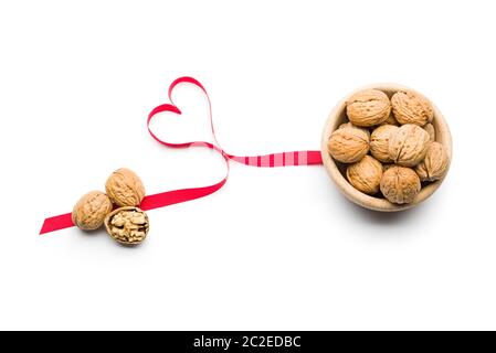 Three nuts a day for heart health, walnuts on bowl on white background Stock Photo