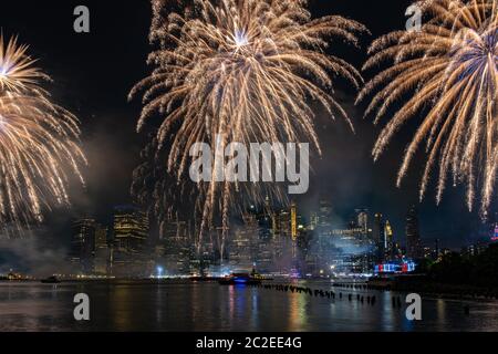 Macy's 4th of July Independence Day Fireworks show on east river with Lower Manhattan Skyline Stock Photo