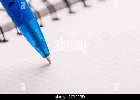 Opened notepad in a cage with an automatic plastic ballpoint pen close-up. Stock Photo