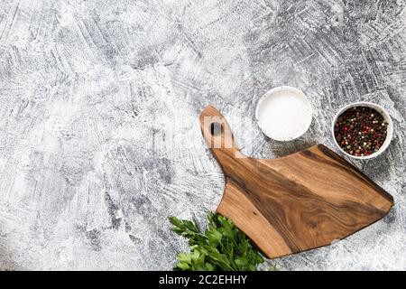 Spices, Herbs, Wooden Cutting board for cooking. Cutting board on grey concrete backdrop. Top view with copy space for text. Menu, recipe mock up, ban Stock Photo