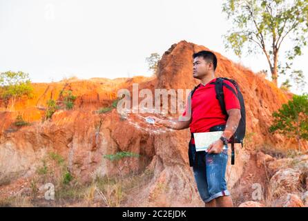 Traveller man using smart compass observing map to find the the right way, Future hologram technology concept Stock Photo