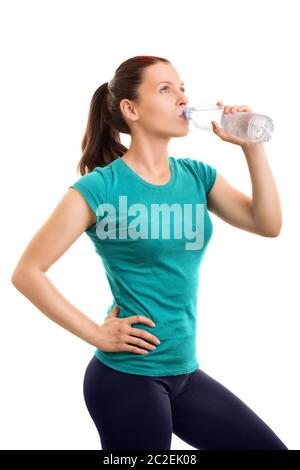 Keep yourself well hydrated while exercising. Beautiful young girl drinking water after her workout, isolated on white background. Stock Photo