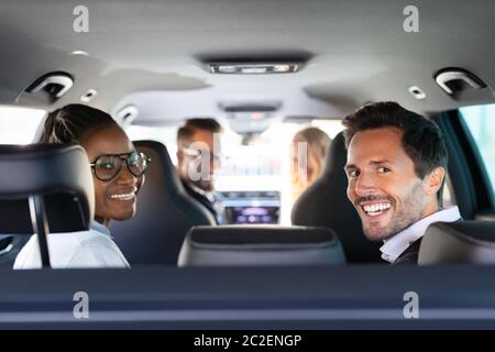 Group Of Cheerful Multi Racial Friends Sitting In Car Enjoying Road Trip Travel Stock Photo