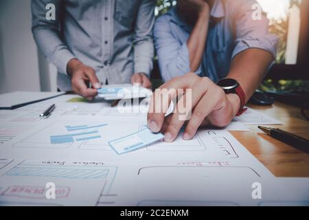 UX or UI designers designing on their smartphone application layout prototype project. Stock Photo
