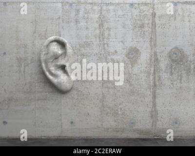 Cement sculpture in the shape of a human ear on a concrete wall. Illustration of the metaphor 'Even walls have ears.' Creative conceptual modern art w Stock Photo