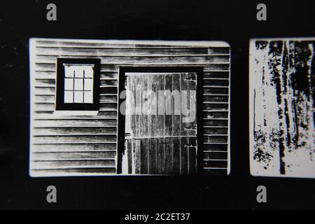 Fine 70s vintage contact print black and white extreme photography film negative of a rustic old cabin door and window. Stock Photo