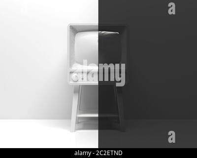 Old black and white tv in the interior divided in half into two parts in the middle.  One half is white, the other half is black. Creative conceptual Stock Photo