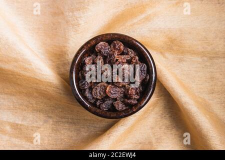 Still life of raisins in a ceramic bowl on a decorative cloth Stock Photo
